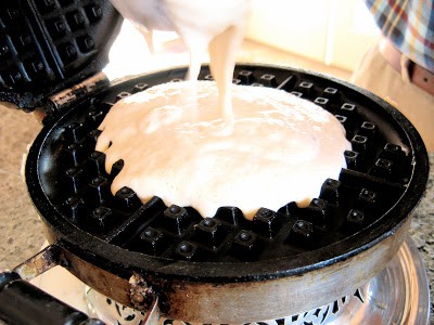 batter being poured into a waffle iron
