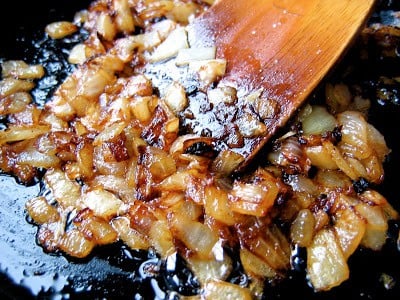 onion being stirred in a pan