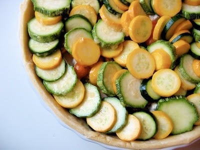 top down shot of tomato and zucchini tart before cooking