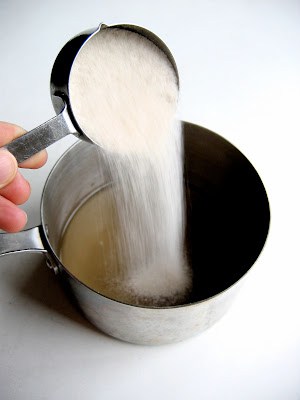 sugar being poured into a pan