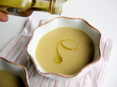truffle oil being poured into celriac soup 