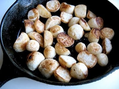 a skillet full of turnips cooking 