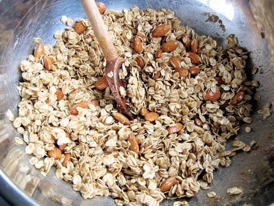 oats and nuts in a bowl being stirred 