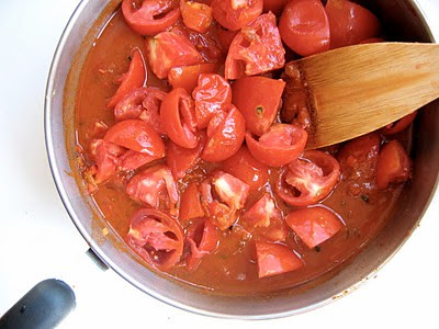 tomatoes being stirred in a pot