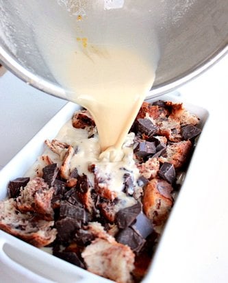 wet ingredients being poured onto chocolate bread pudding 