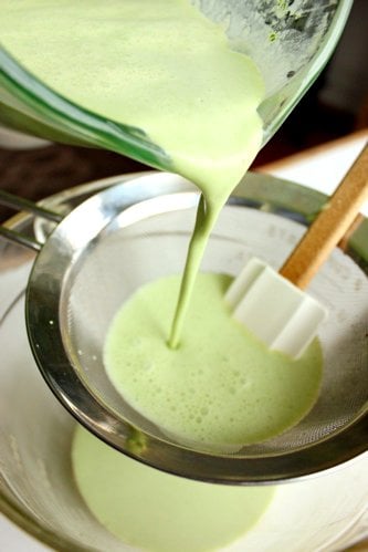 ice cream mix being poured through a sieve 