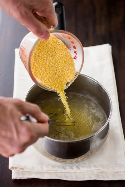 polenta being mixed into liquid 