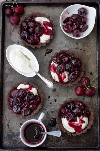 chocolate cherry goat cheese tarts with a bowl of cherries 