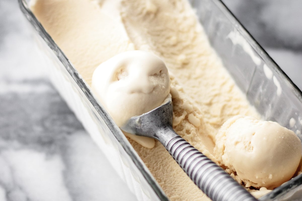 ice cream has been partially scooped out of a glass pan