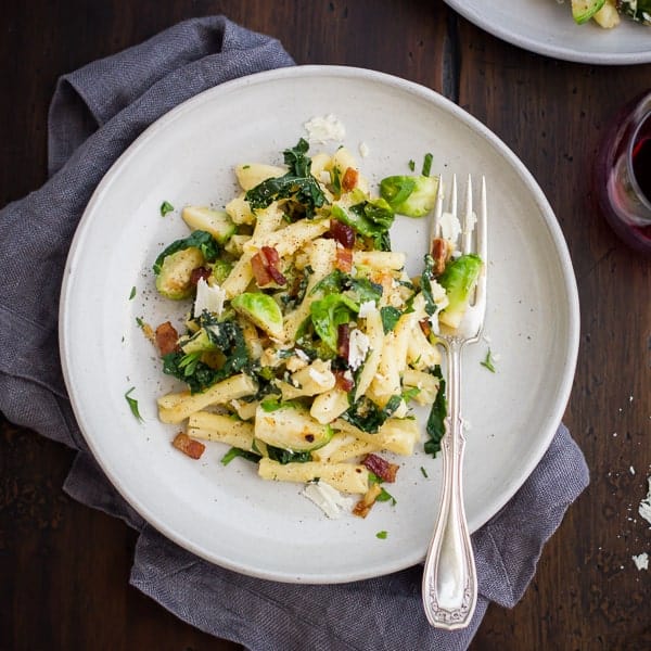 Pasta alla Carbonara with Kale, Brussels Sprouts, and Bacon on table 