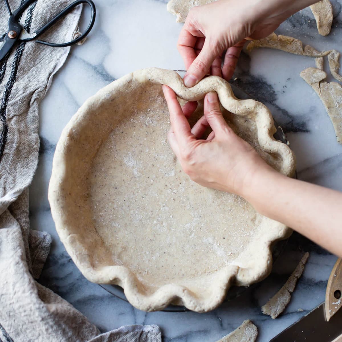 hands are fluting a gluten-free pie crust