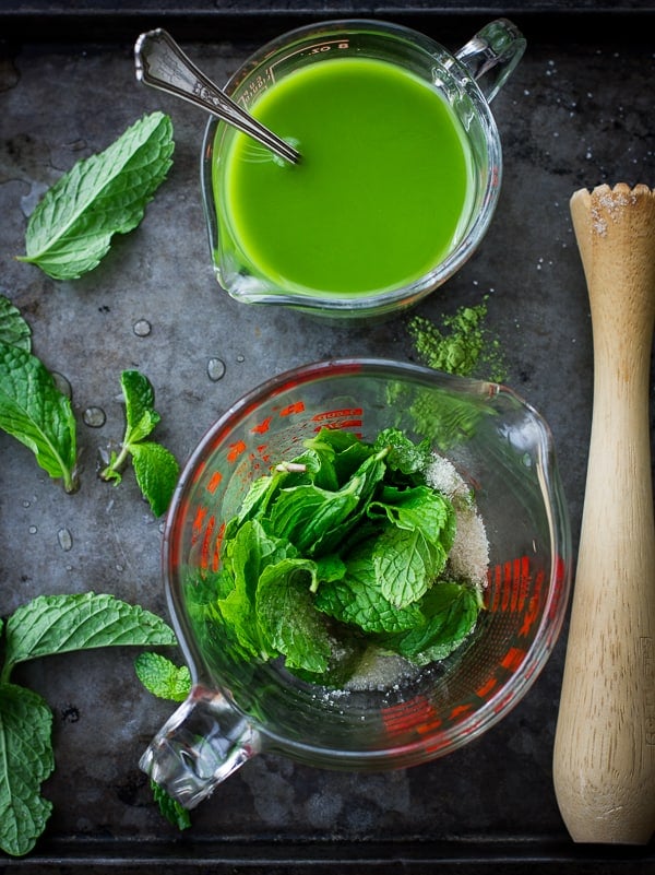 matcha mixture and mint being muddled with sugar