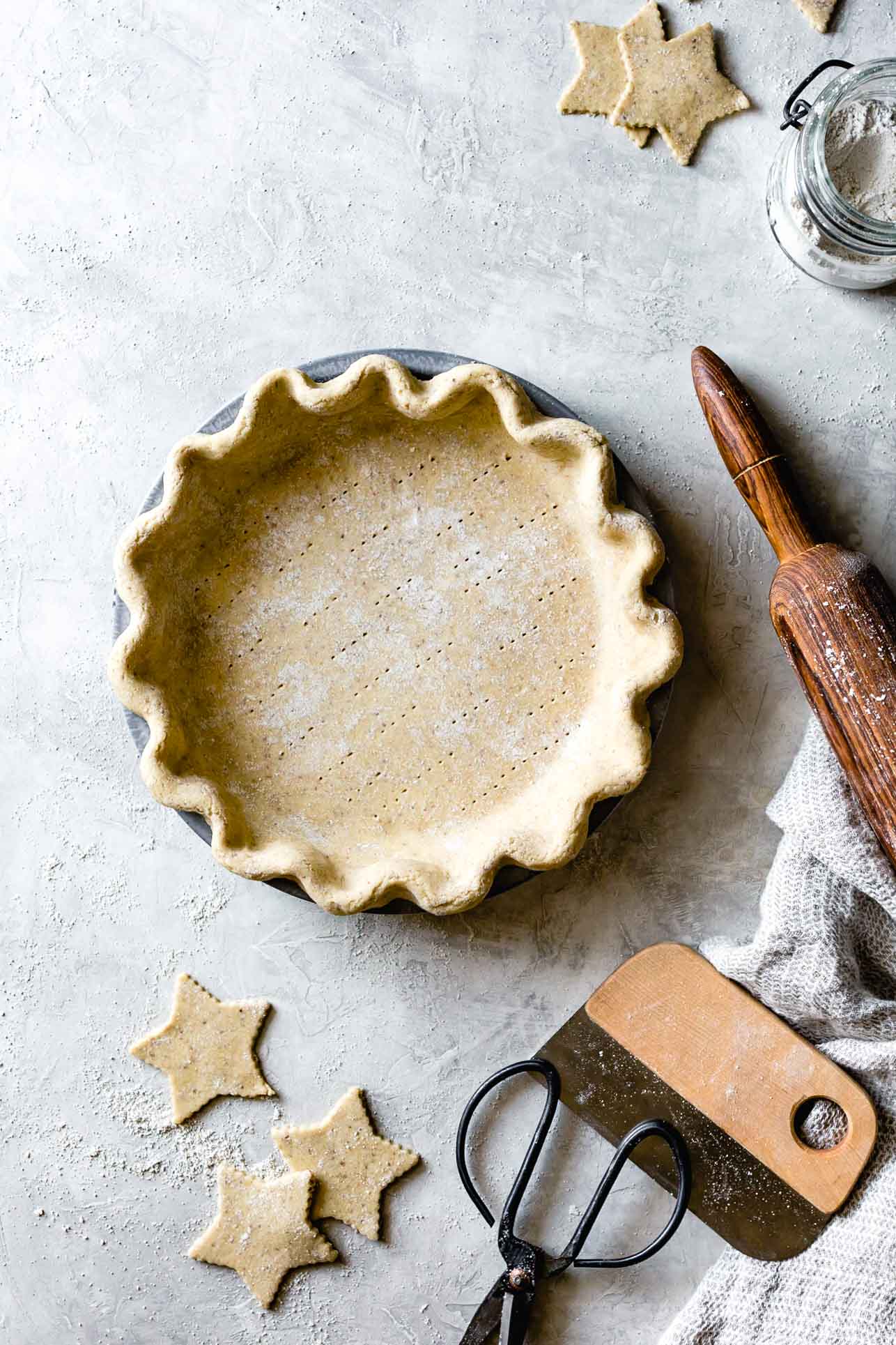 an unbaked gluten-free pie crust made with sweet rice, millet, and oat flours sits on a plaster surface