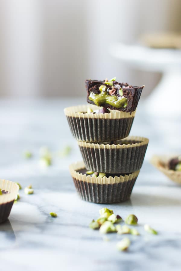 tall stack of Raw Chocolate + Pistachio Butter Cups