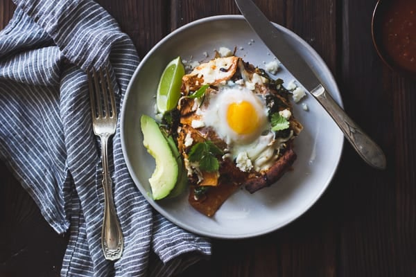 Baked Chilaquiles with Black Beans and Kale on a plate with knife and fork