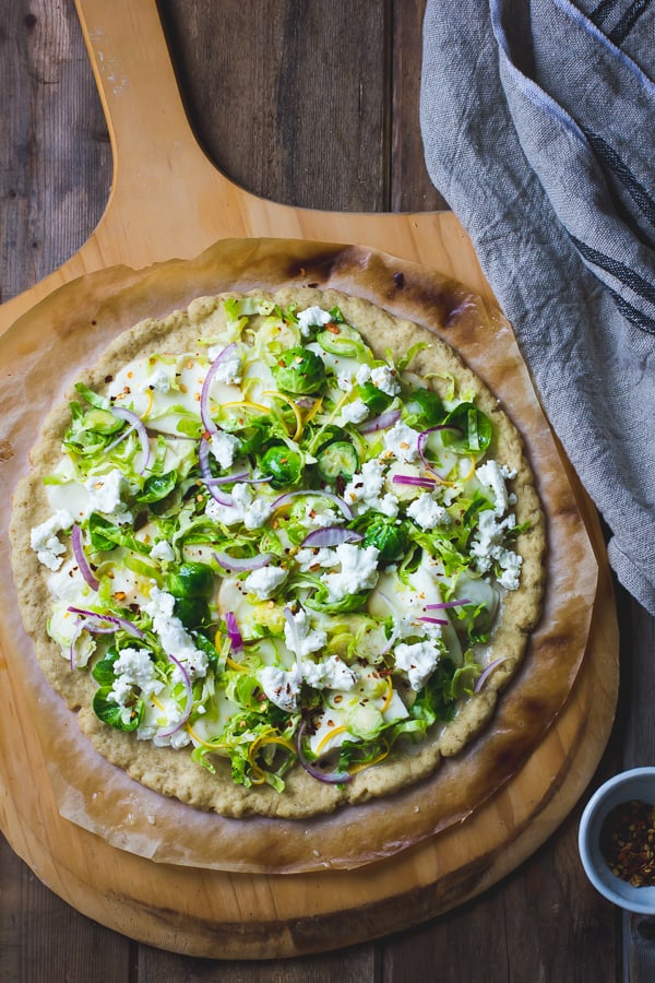 Smoky Brussels Sprout Pizza with Lemon + Chile on a board 
