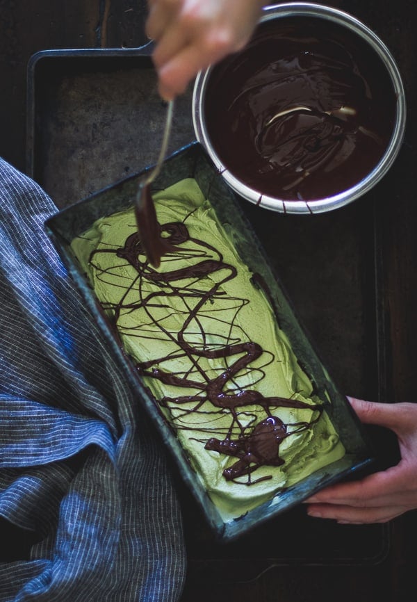 drizzling chocolate on tray of Matcha Mint Chip Ice Cream