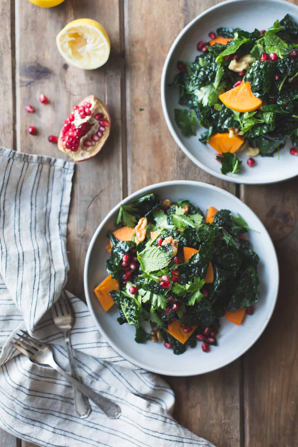 plates of Herbed Kale Salad with Persimmon, Pomegranate and Maple-Cumin Dressing