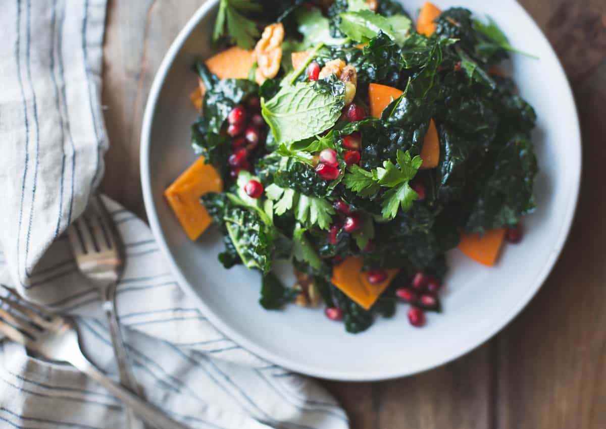 plate of Herbed Kale Salad with Persimmon, Pomegranate and Maple-Cumin Dressing
