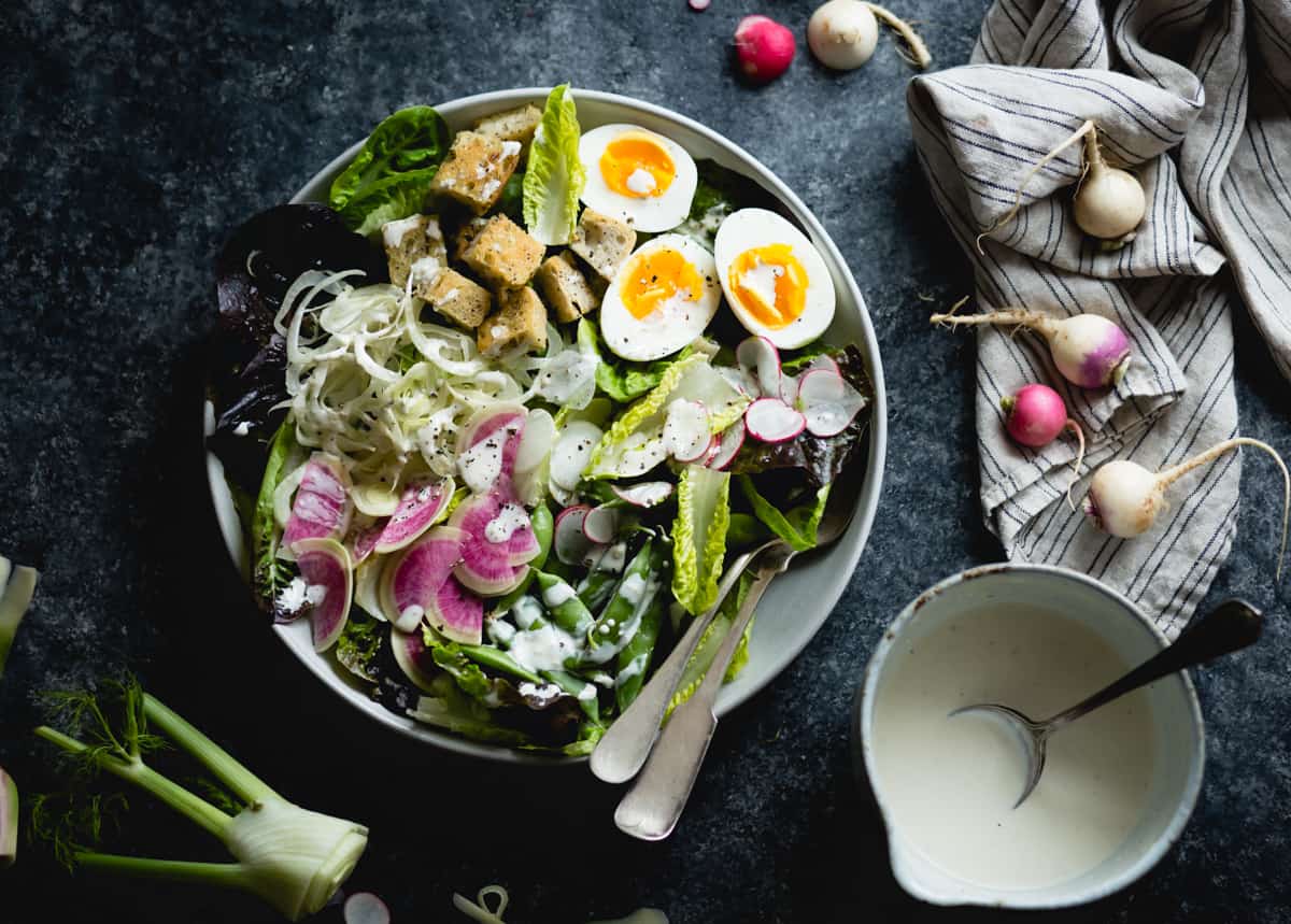 bowl of spring greens salad with fennel, radish, and miso-buttermilk dressing