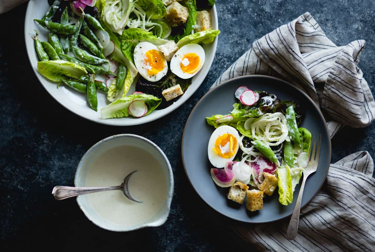 plate and bowl of spring greens salad with fennel, radish, and miso-buttermilk dressing