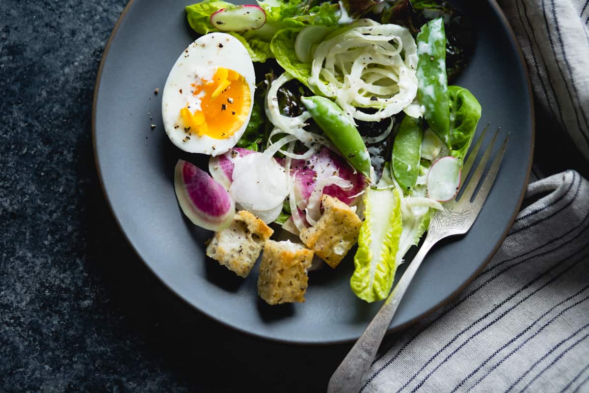 a plate of spring greens salad with fennel, radish, and miso-buttermilk dressing