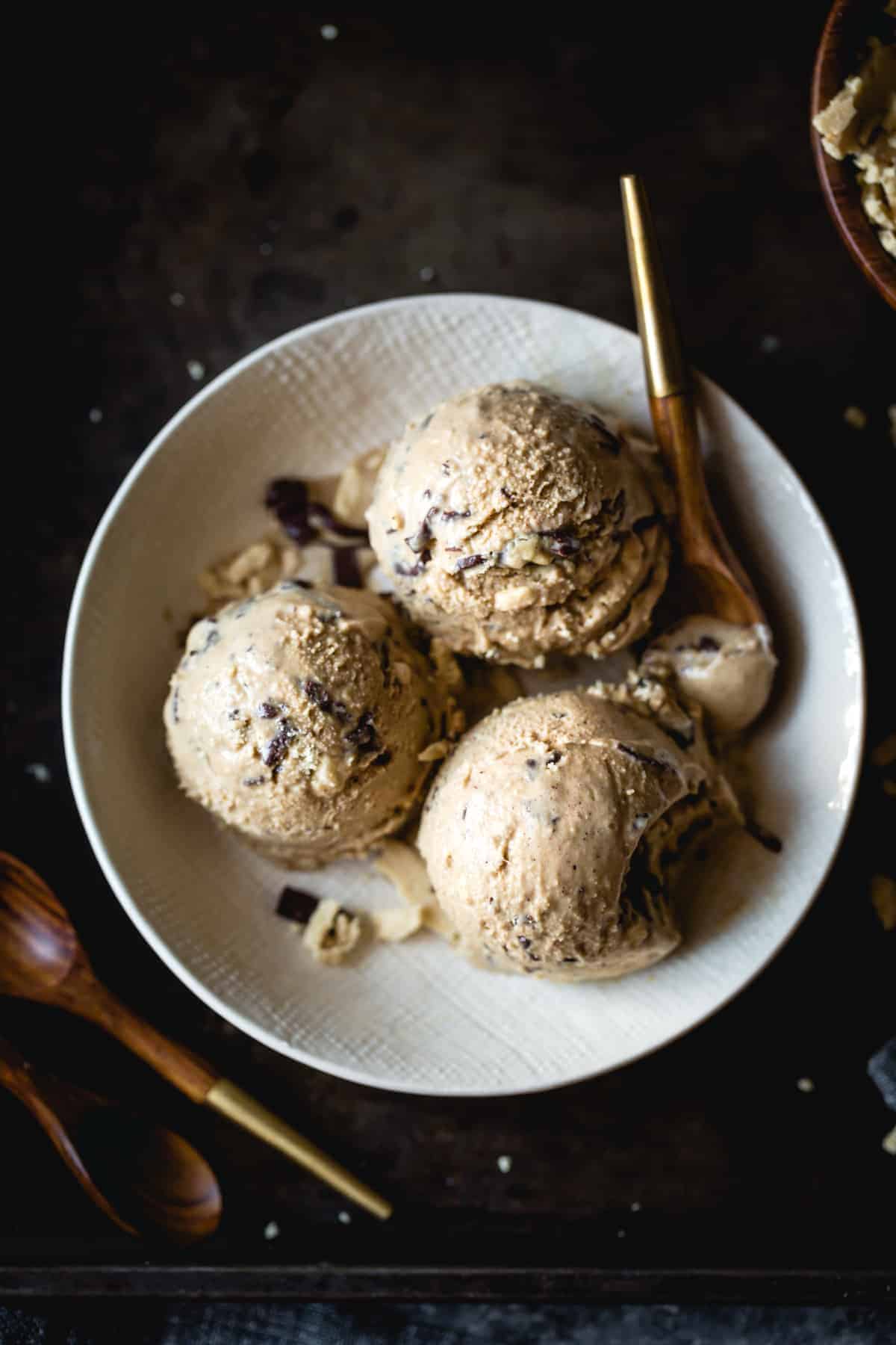 Coffee Halva Chocolate Chip Ice Cream in a white bowl with wooden spoons