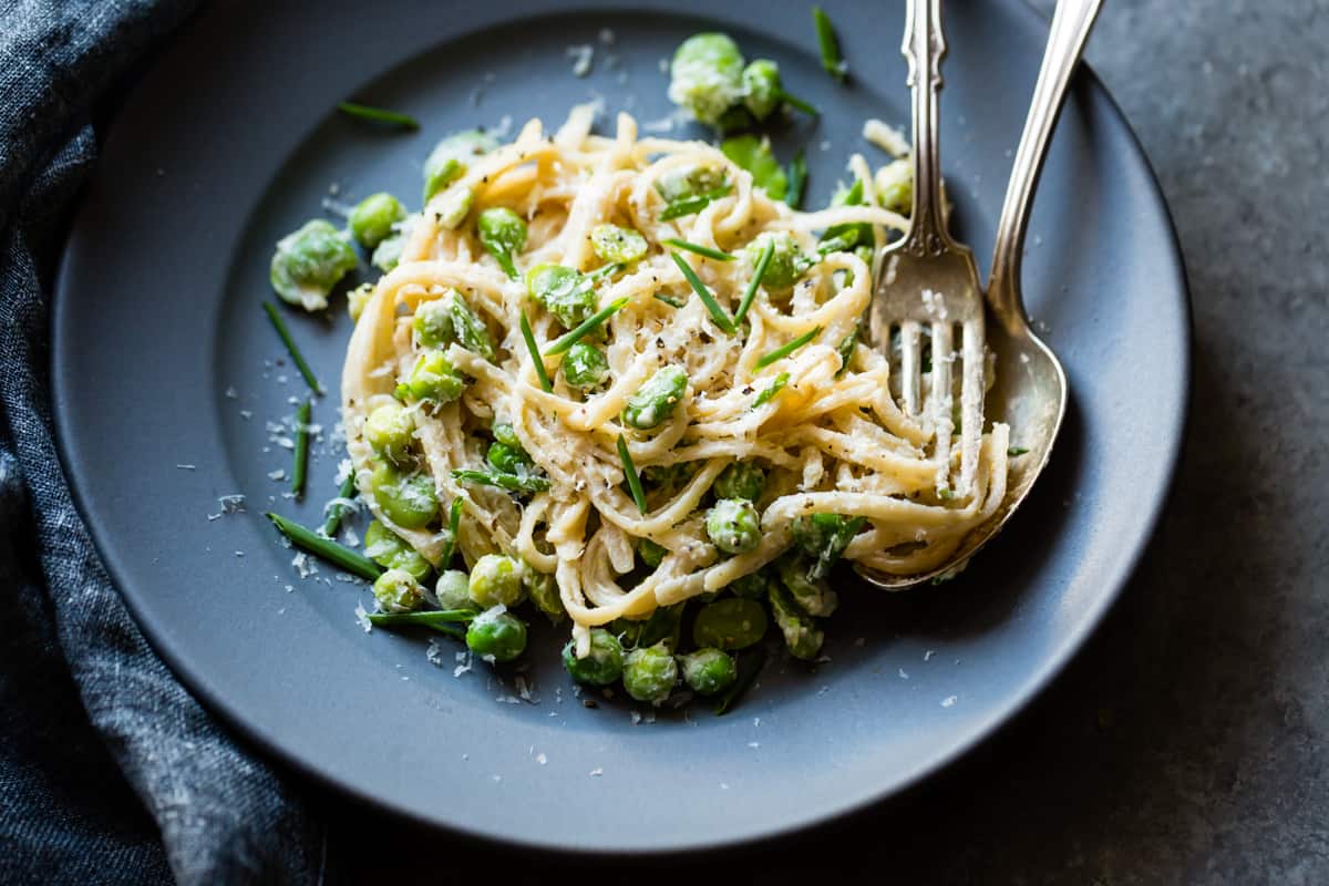 a plate of Creamy Cashew-Miso Pasta with Peas and Fava Beans {gluten-free, vegan option}