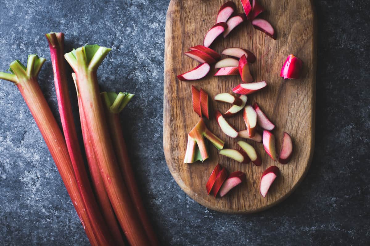 rhubarb being prepped for dessert on a wood board