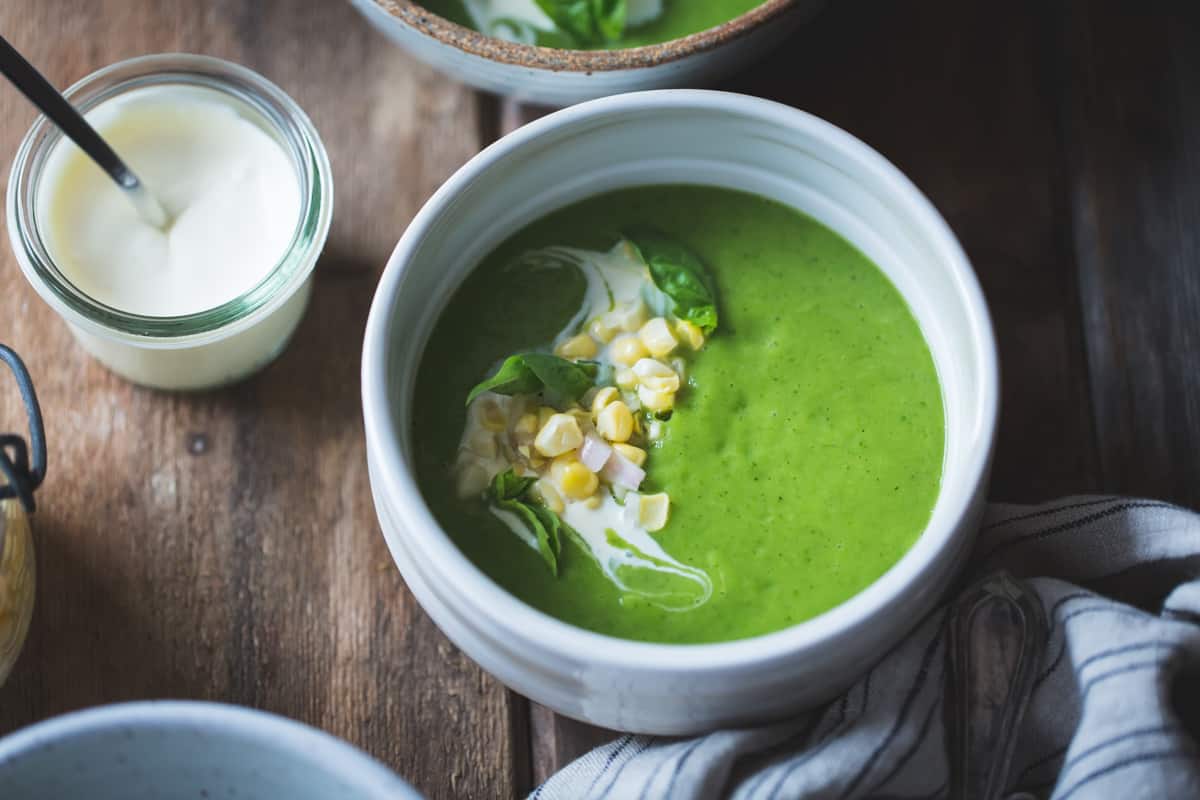 a bowl of Zucchini Basil Soup with Crème Fraîche and Pickled Corn