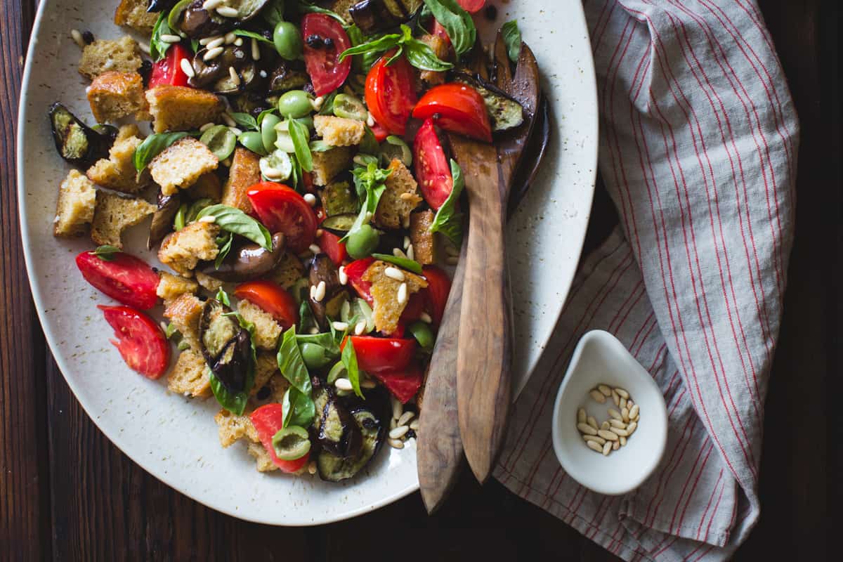 Roasted Eggplant Panzanella with Capers, Olives, and Pine Nuts {gluten-free, vegan option} on table 