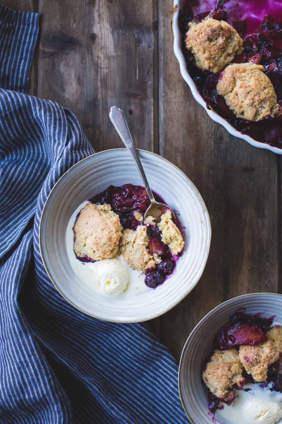 bowl of Gluten-Free Blueberry Plum Cobbler with Corn Flour Biscuits