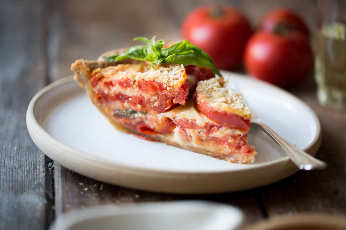 side shot of slice of Tomato Pie with Basil, Parmesan + Cornmeal {gluten-free}