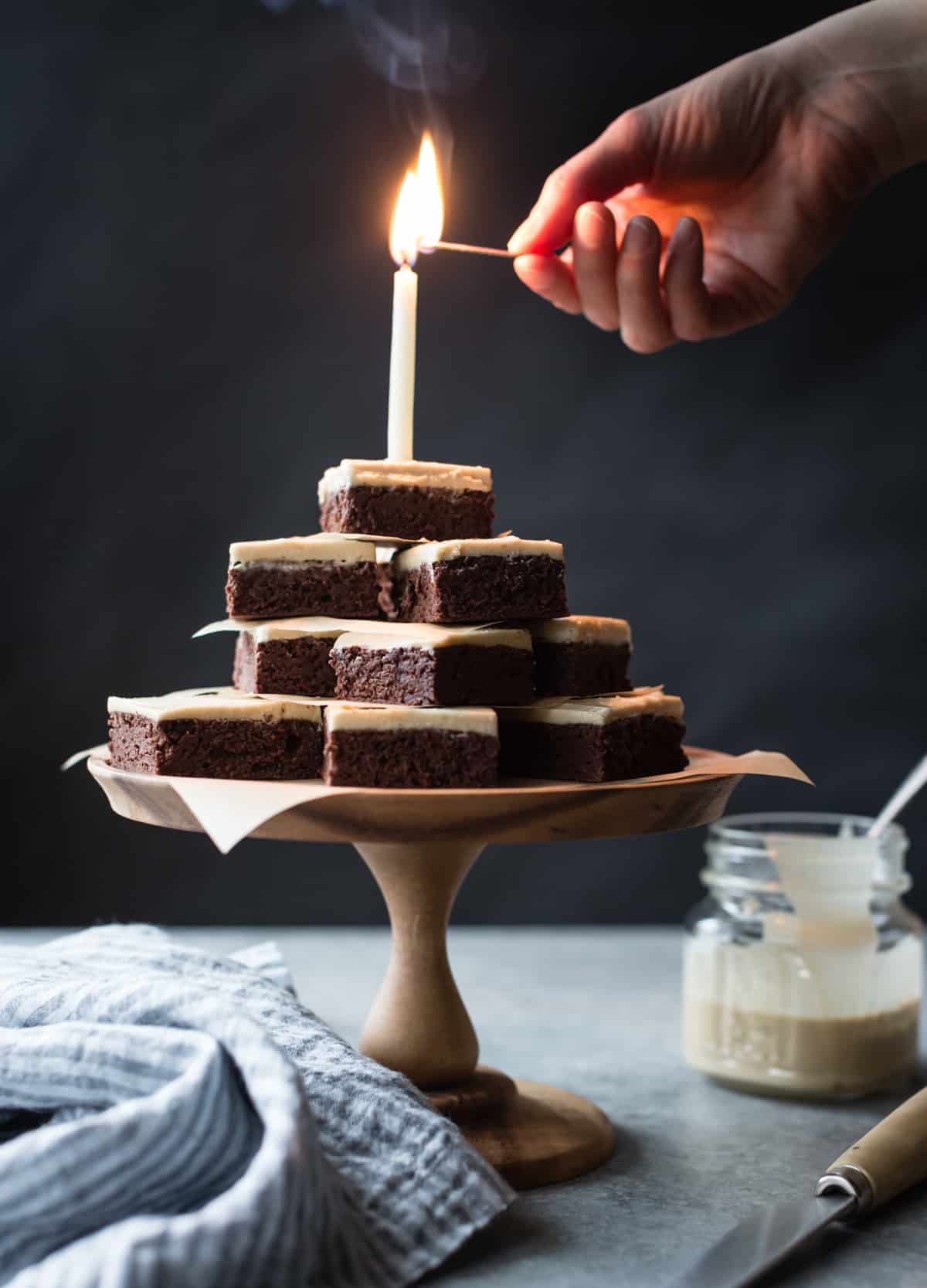candle on stack of Teff Brownies with Salted Tahini Frosting {gluten-free}