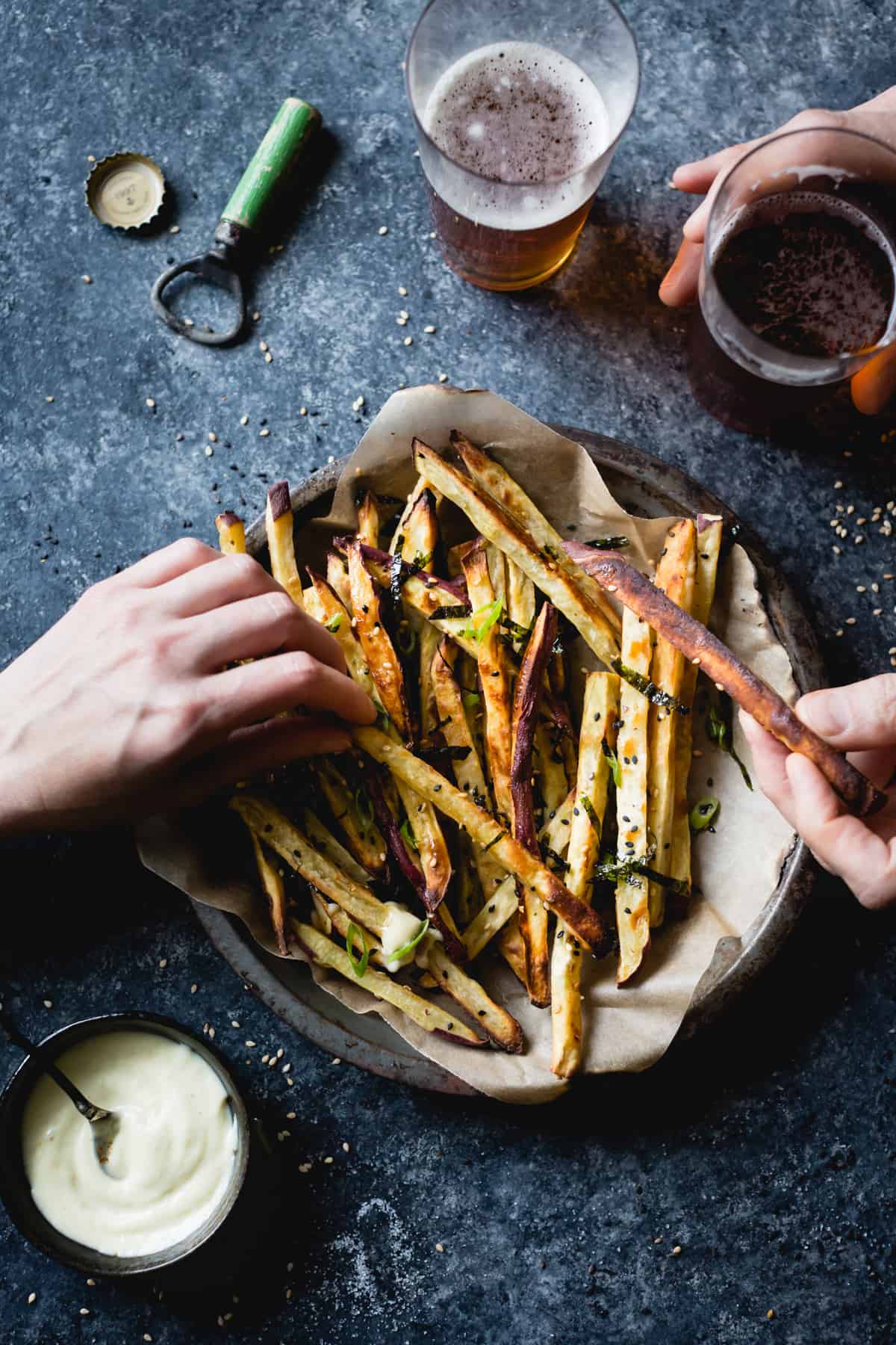 hands picking up some Japanese Sweet Potato Oven Fries with Wasabi Aioli