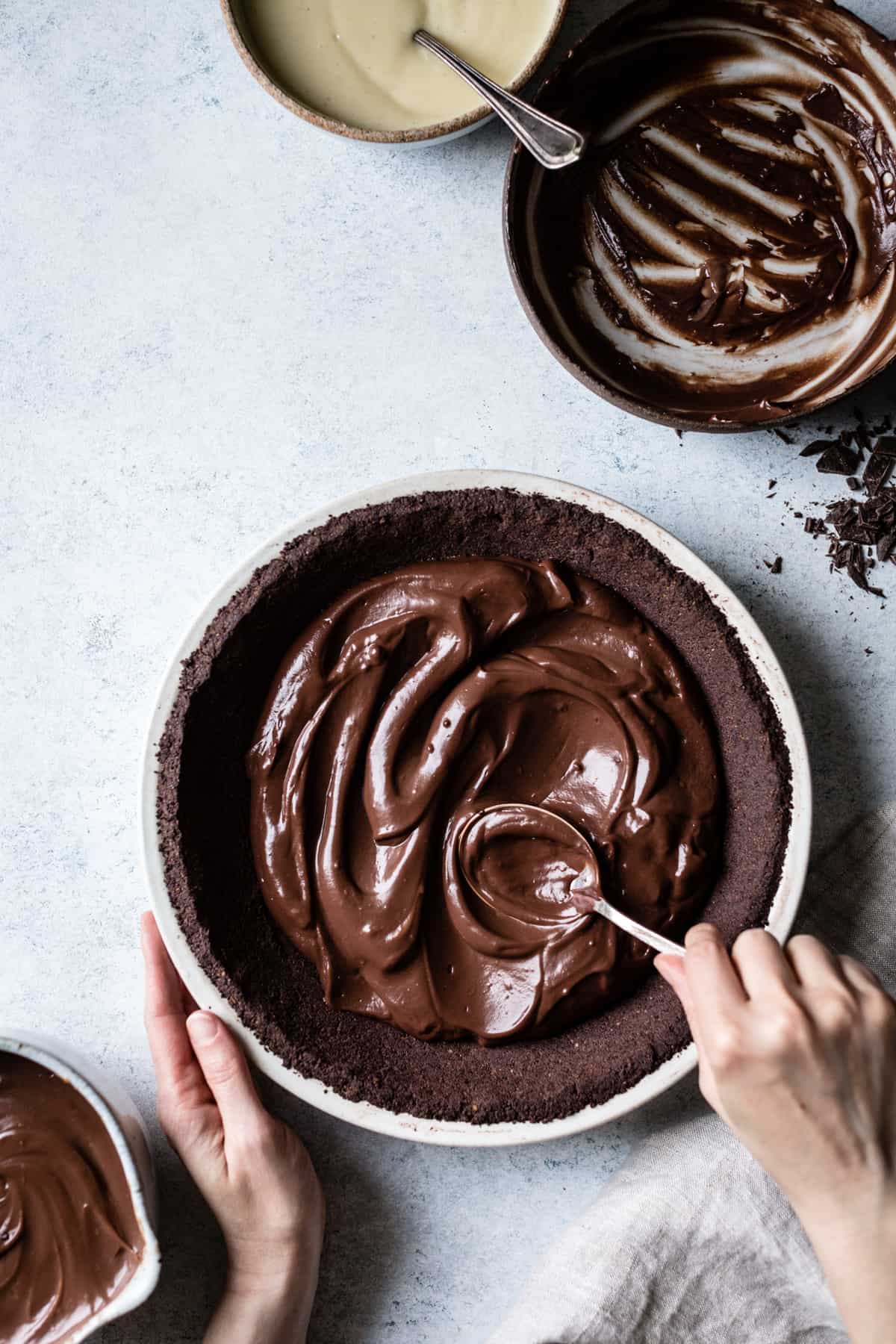 spooning chocolate filling onto pie crust 