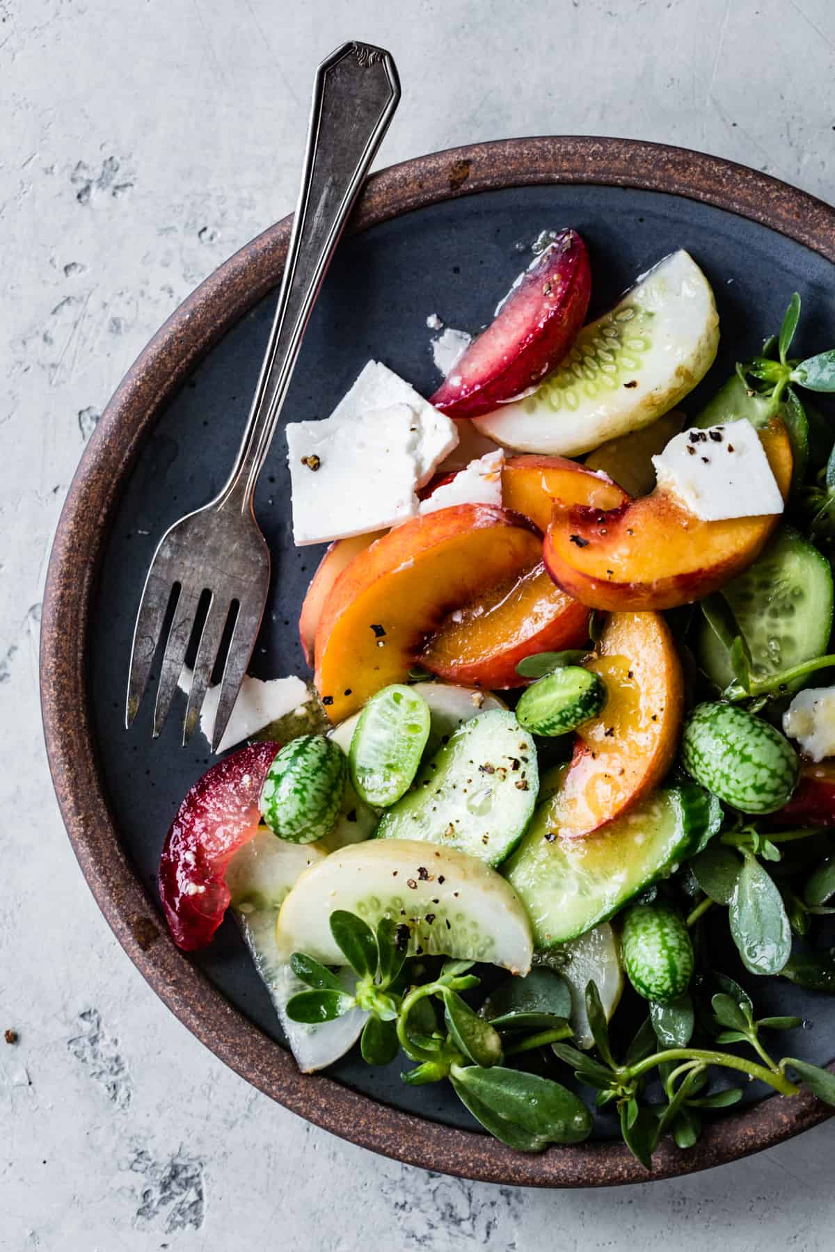 plated Stone Fruit Cucumber Salad with Ricotta Salata, Purslane, and Golden Balsamic Miso Vinaigrette