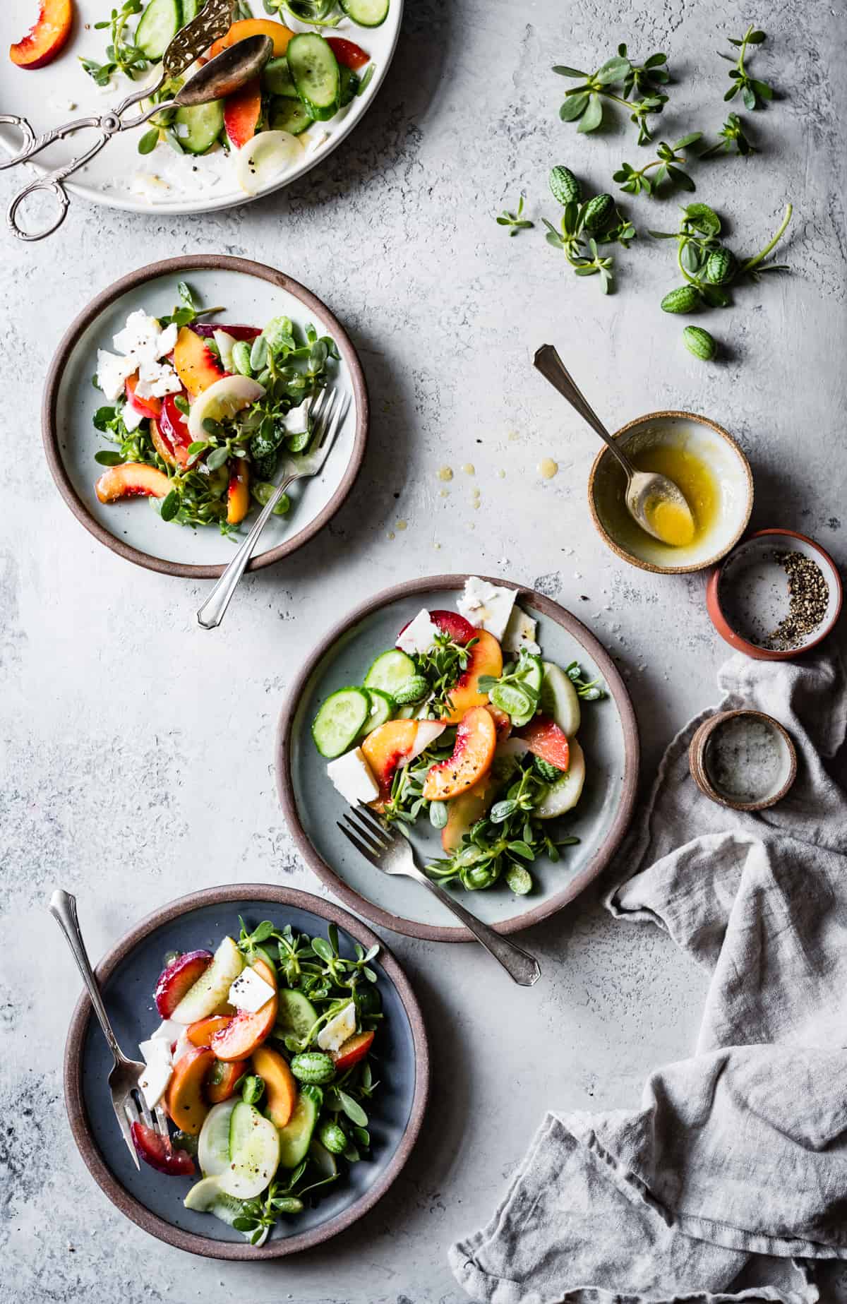 Stone Fruit Cucumber Salad with Ricotta Salata, Purslane, and Golden Balsamic Miso Vinaigrette on table 