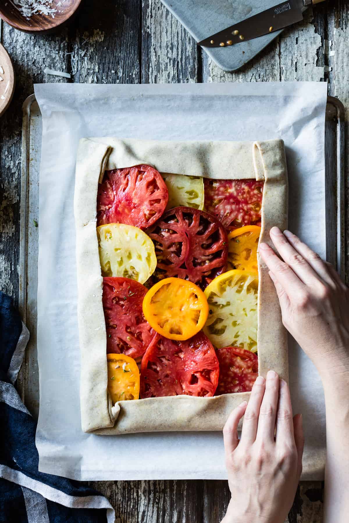 folding pastry around tomatoes 