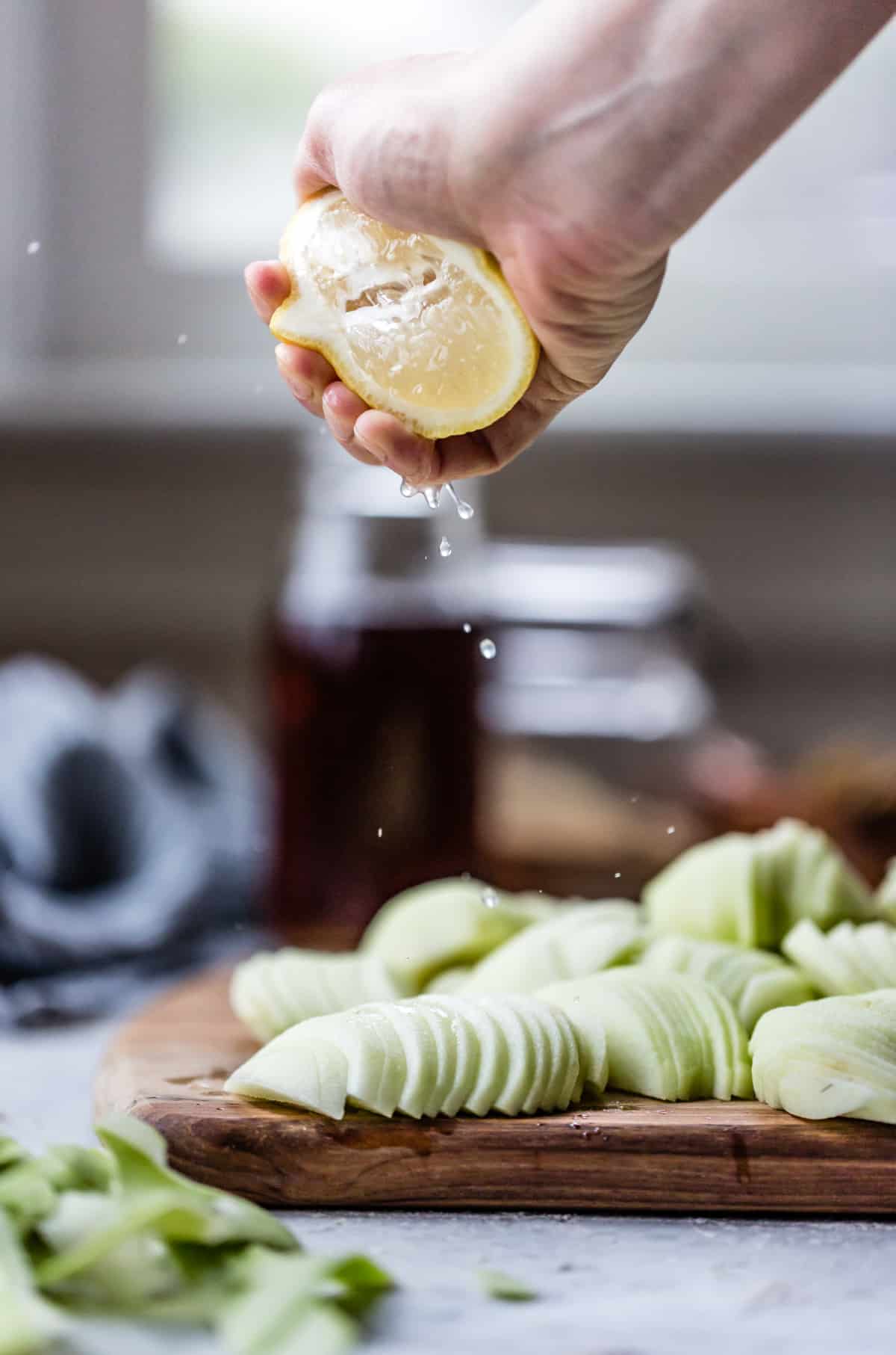 squeezing lemon juice on apple slices 