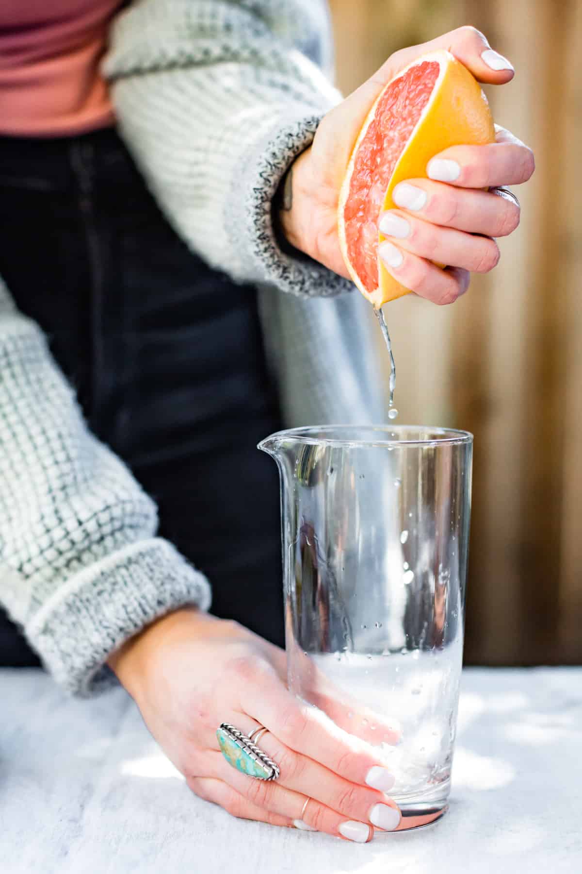 squeezing grapefruit juice into jug 