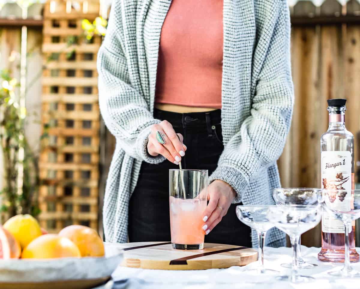 someone stirring Sparkling Grapefruit, Elderflower & Rosé Vodka Cocktails