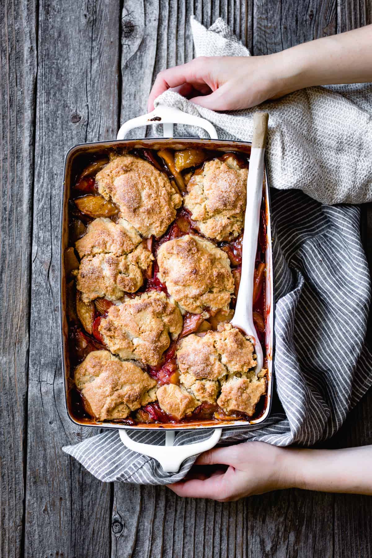 hands holding Gluten Free Apple Cobbler with Maple & Rhubarb