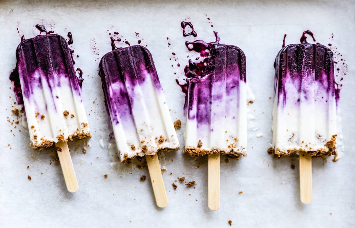 row of four Blueberry Chèvre Cheesecake Popsicles