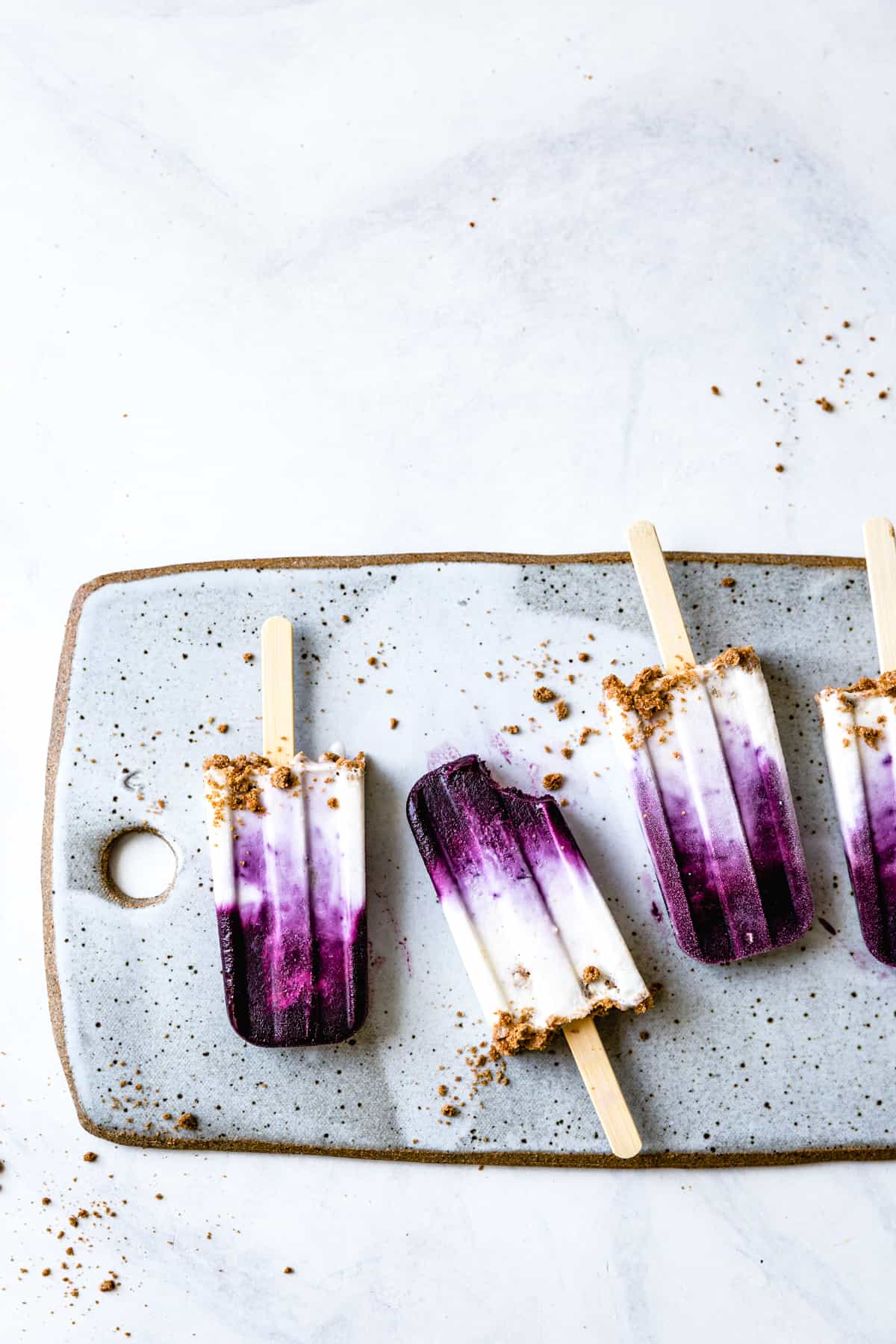 row of four Blueberry Chèvre Cheesecake Popsicles