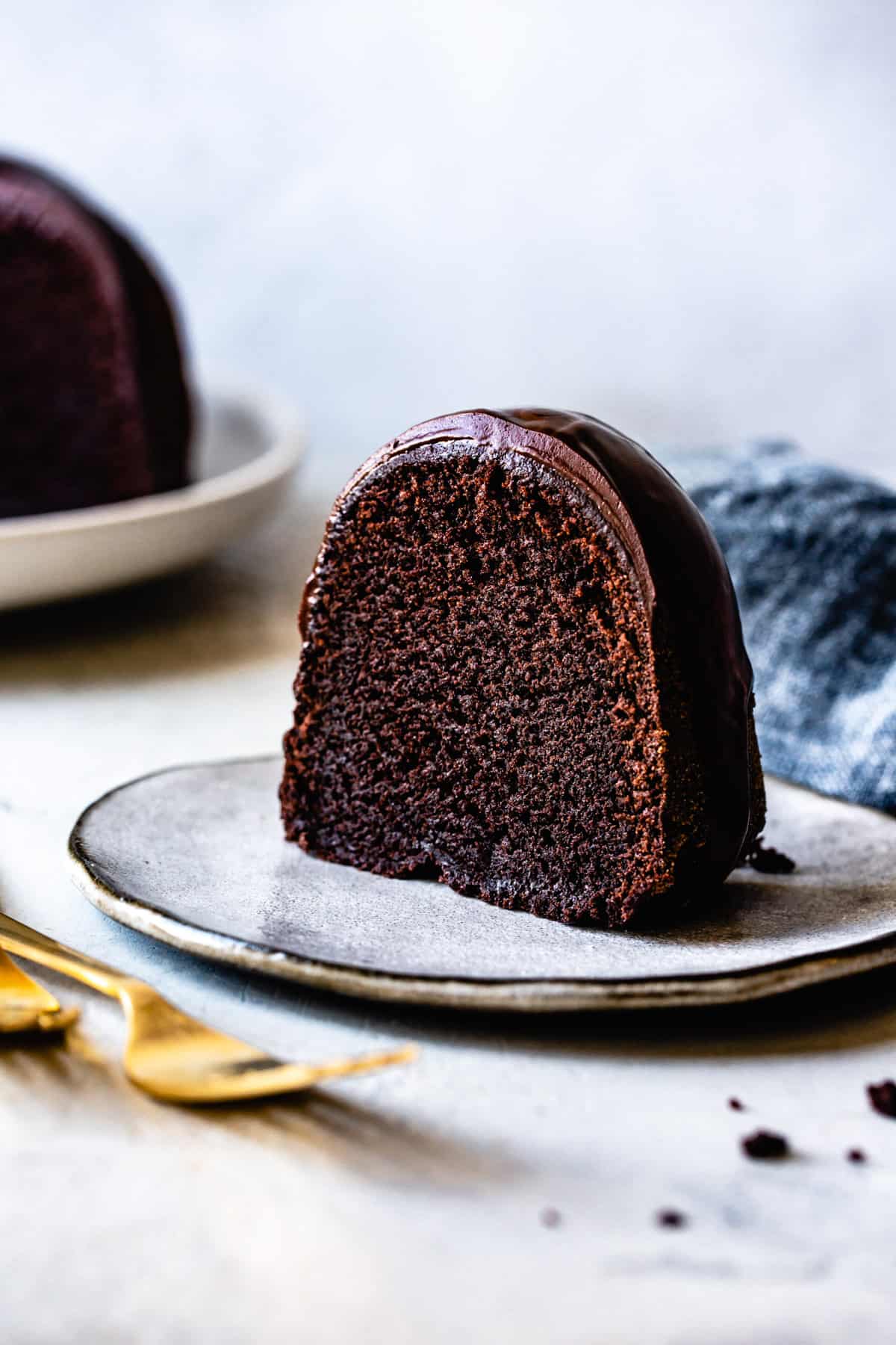 a slice of chocolate bundt cake shows off its fudgy crumb