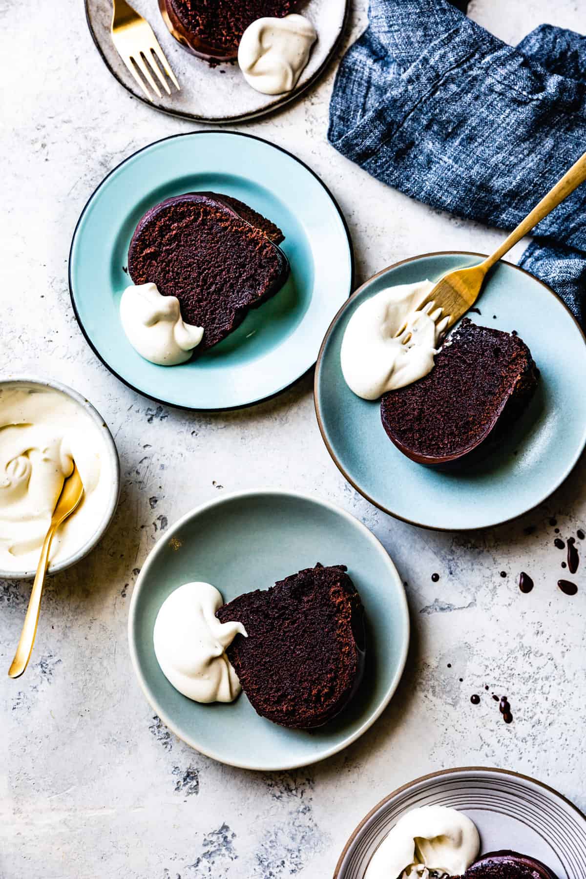 several slices of chocolate bundt cake all smothered in silky creme fraiche whipped cream