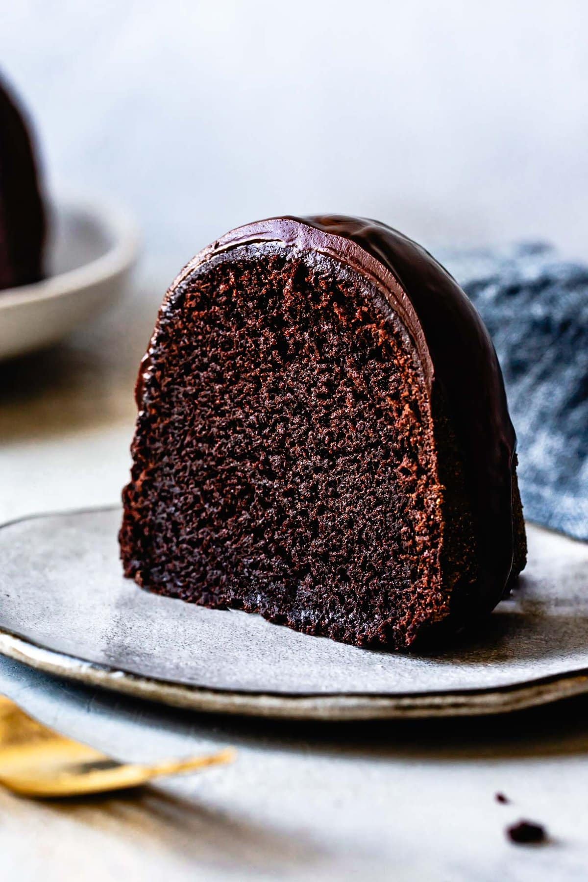 close-up slice of gluten-free chocolate bundt cake showing off it's moist crumb and gooey texture