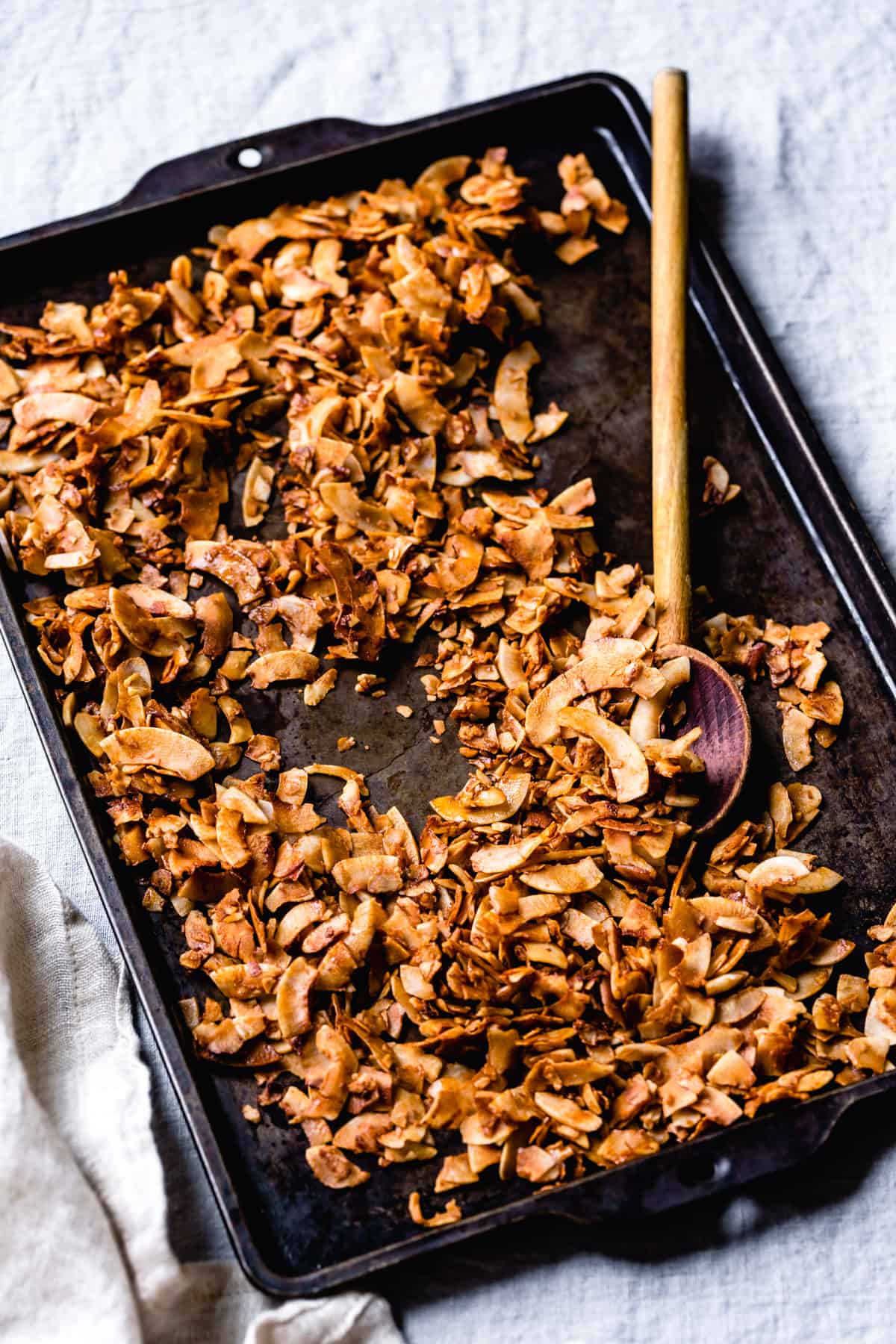 Crispy coconut flake bacon has been baked on a dark sheet pan