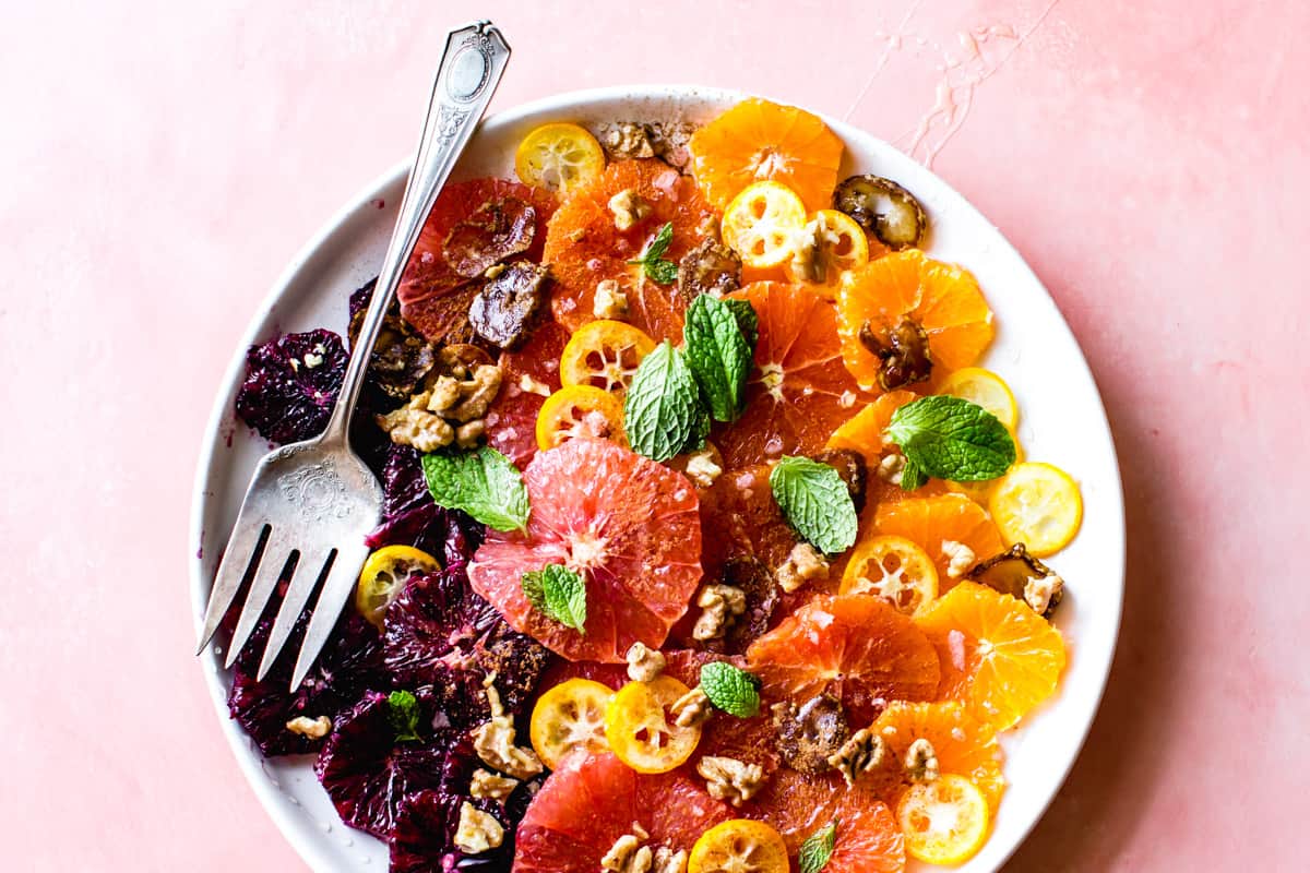 Winter Citrus Salad with Walnuts, Dates & Rose on a plate